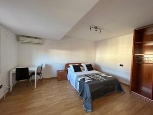 a bedroom with a bed and a desk and a table at Casa Grabo in Cors