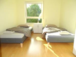 two beds in a room with a window at Zentrale 3,5 Zimmer Wohnung bis zu 6 Personen in Rudersberg in Rudersberg