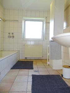 a bathroom with a tub and a sink and a window at Zentrale 3,5 Zimmer Wohnung bis zu 6 Personen in Rudersberg in Rudersberg