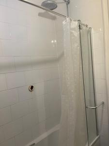 a shower with a shower curtain in a bathroom at Chelsea Manor Studio in London