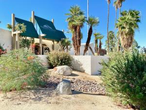 ein Gebäude mit Palmen davor in der Unterkunft Two Chic at Mountain Shadows in Palm Springs