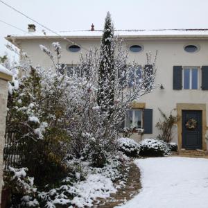 dom z pokrytym śniegiem dziedzińcem w obiekcie Le Clos Fanny chambre d’hôtes 