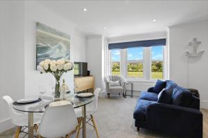 a living room with a blue couch and a table at Ahoy There! in Hythe