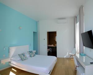 a bedroom with a bed and a desk with a television at Ca del Lac Rooms in Castro