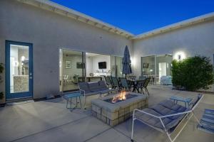 eine Terrasse mit einer Feuerstelle, Stühlen und einem Tisch in der Unterkunft Deja Blue in Palm Springs