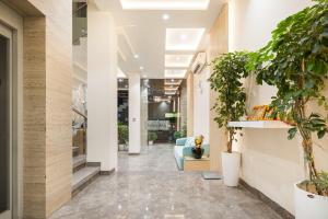 a corridor of a lobby with potted plants at Hotel Meghdoot, Bhopal in Bhopal