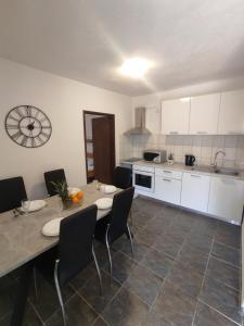 eine Küche mit einem Tisch und Stühlen im Zimmer in der Unterkunft Apartmani Paraiso in Sevid