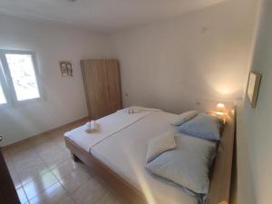 ein Schlafzimmer mit einem großen weißen Bett mit blauen Kissen in der Unterkunft Apartmani Paraiso in Sevid