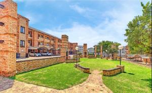 an exterior view of a brick building with a yard at Studio Eazi in Midrand