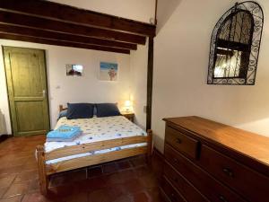 a bedroom with a bed with a dresser and a mirror at Gite de charme en pierres apparentes : Les Granges in Gardonne