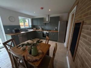 cocina con mesa de madera con sillas y comedor en 3 - Rabbit Warren, Bright décor home & private hot tub, en Norwich