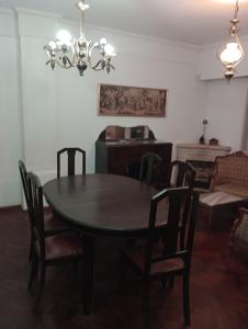 mesa de comedor con sillas y lámpara de araña en Cómo en casa en Rosario