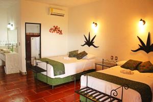 a hotel room with two beds and a bathroom at Wellness Center El Secreto in Tepoztlán
