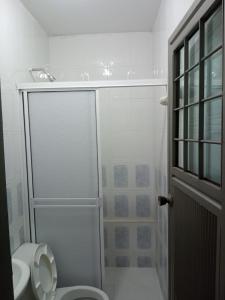 a white bathroom with a shower and a toilet at Hotel La Bastilla PEP in Sincelejo
