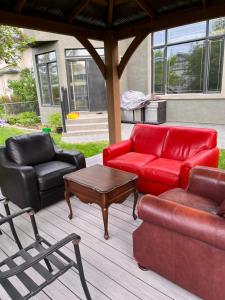 um pátio com um sofá vermelho, uma mesa e cadeiras em Youth hostel 2 em Calgary