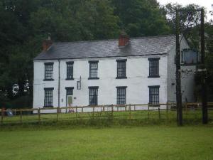 a white house with a fence in front of it at The Old Postie Bed & Breakfast in Annesley