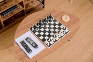 um tabuleiro de xadrez e um controlo remoto numa mesa em Entire 2 Bed, 5 mins 2 Game City, Netflix & Ps4 em Gaborone