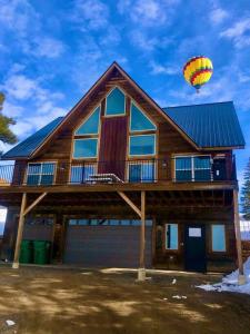 a house with a hot air balloon flying over it at The “Worst” Home, Best Stay In Pagosa Springs in Pagosa Springs