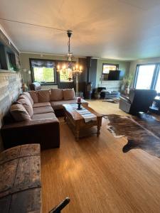 a living room with a couch and a coffee table at Hjelvikhytta - flott beliggenhet ved sjøen in Hjelvik