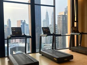 un gimnasio con 3 cintas de correr frente a una ventana en Axon Luxury Suites KL, en Kuala Lumpur