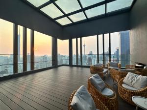 Habitación grande con sillas, mesas y ventanas. en Axon Luxury Suites KL en Kuala Lumpur