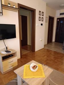 - un salon avec une table et une plaque de pizza dans l'établissement Apartman 34, à Subotica