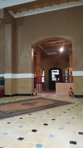 an empty room with a tile floor and an archway at Riad pizzeria Marhaba in Akhendachou nʼAït Ouffi