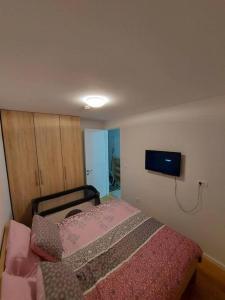 um quarto com uma cama e uma televisão na parede em Apartman ED em Jahorina