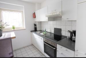 a kitchen with white appliances and a black counter top at Ottostadt in Magdeburg