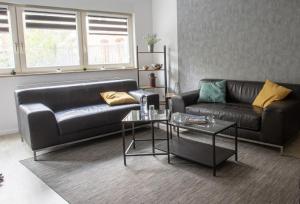 a living room with a leather couch and a table at Ottostadt in Magdeburg +2 photos