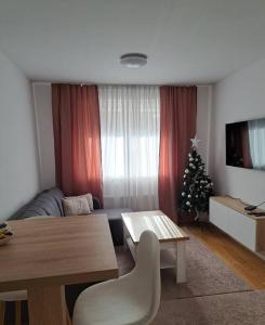 a living room with a table and a christmas tree at Apartman ED in Jahorina