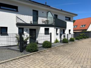 ein weißes Haus mit einem Balkon und einer Auffahrt in der Unterkunft Ferienhäuser Unikat A&B in Bad Harzburg
