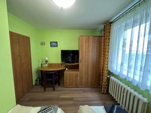 een woonkamer met een tafel en een televisie en een kamer bij Kwatera Kryształowa 