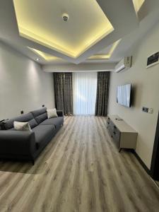 Golden Stone Hotel في إسطنبول: غرفة معيشة مع أريكة وتلفزيون