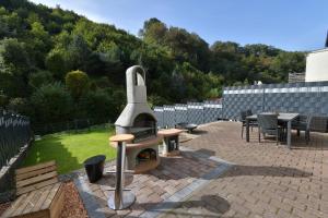 a patio with a pizza oven in a backyard at Ferienhaus am Bach in Koblenz