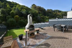 eine Terrasse mit einem Pizzaofen im Hinterhof in der Unterkunft Ferienhaus am Bach Koblenz in Koblenz