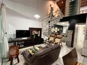 ein Wohnzimmer mit Ledercouch und Fernseher in der Unterkunft Flat 414 Condominio Villa Hípica - Gravatá PE in Gravatá