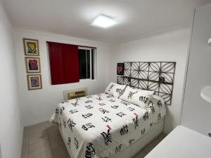a bedroom with a bed with a white comforter at Flat 414 Condominio Villa Hípica - Gravatá PE in Gravatá