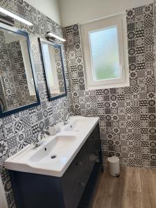 La salle de bains est pourvue d'un lavabo et d'un miroir. dans l'établissement Le Cottage Senlisien, à Senlis