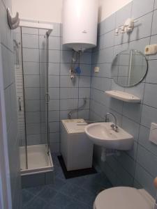 a bathroom with a sink and a toilet and a mirror at Liliom Apartments Balatonfüred in Balatonfüred
