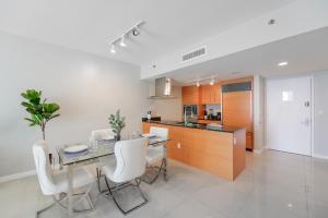 a kitchen with a dining table and white chairs at Luxurious 1/1 Condo at Icon Brickell W/Pool in Miami