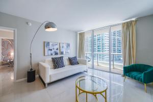 sala de estar con sofá blanco y mesa de cristal en Luxurious 1/1 Condo at Icon Brickell W/Pool en Miami