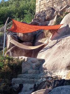 an orange tent on a rocky hill with stairs at Gardunha Stone in Louriçal do Campo