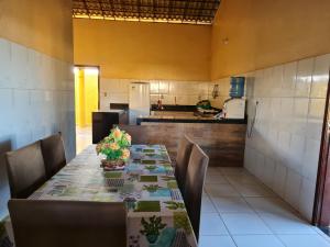 een eetkamer met een tafel en een keuken bij Casa Camboas in Paraipaba