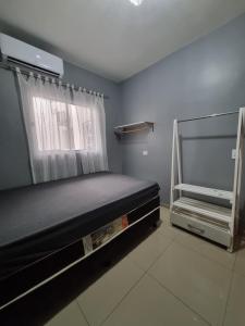 a small bedroom with a bed and a window at Casa com piscina em Guaratuba PR in Guaratuba
