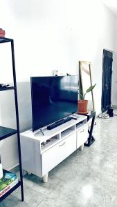 - un salon avec une télévision dans un centre de divertissement dans l'établissement Cozy Apartment in the City Centre - Rayfield Jos, à Zawan