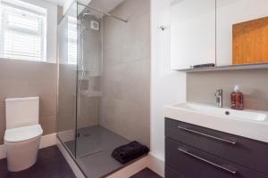 a bathroom with a shower and a toilet and a sink at Beaumont House in Royal Tunbridge Wells