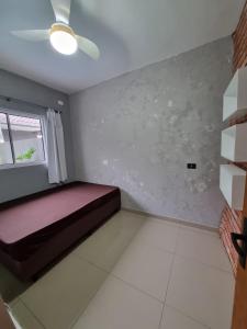 1 dormitorio con cama y ventana en Casa com piscina em Guaratuba PR en Guaratuba