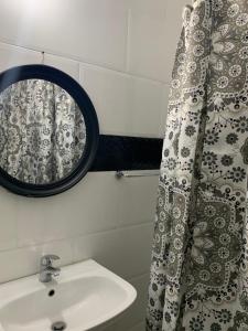 a bathroom with a mirror and a sink at TOWNHOUSE GET-a-WAY in Mandeville