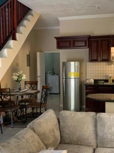 a living room with a couch and a refrigerator at TOWNHOUSE GET-a-WAY in Mandeville